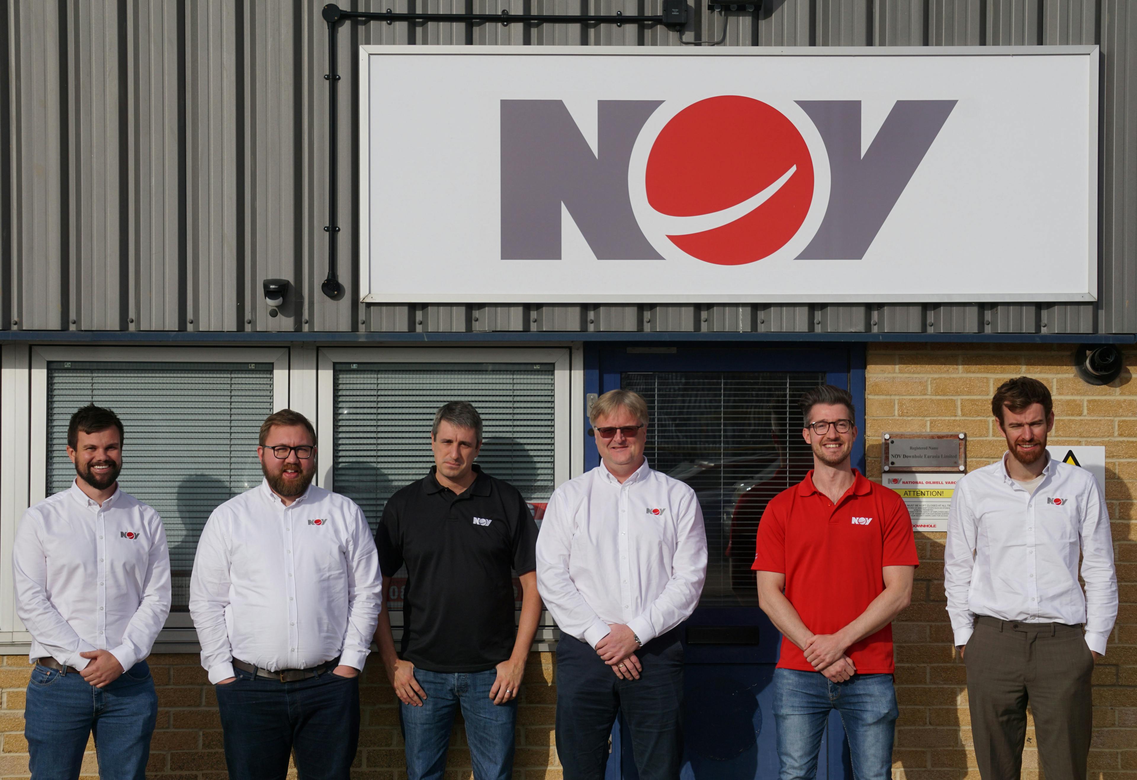 Group photo of the NOV Cable Lay team in front of an NOV building