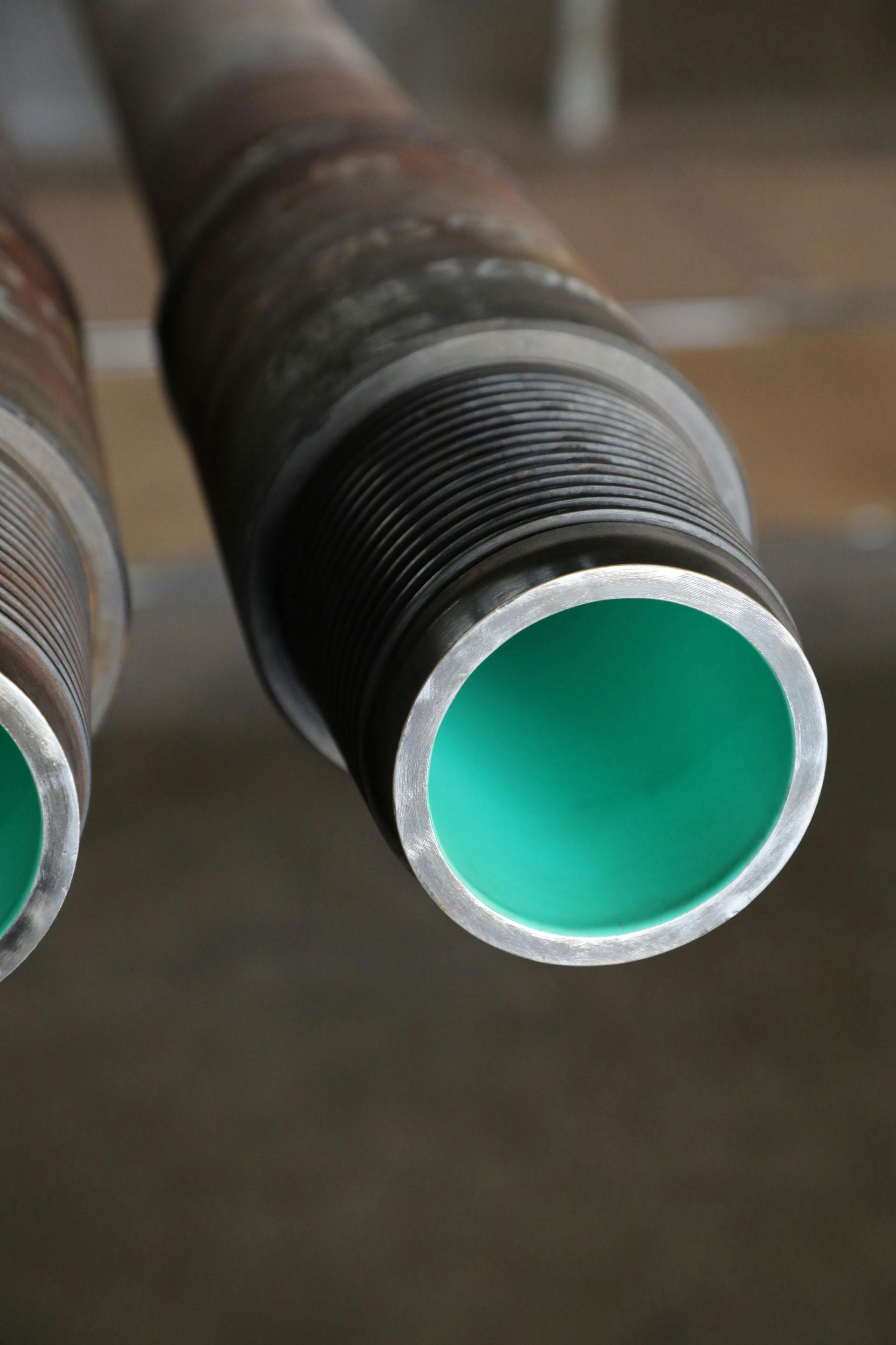 Close up of a coated pipe, inside of pipe is light green
