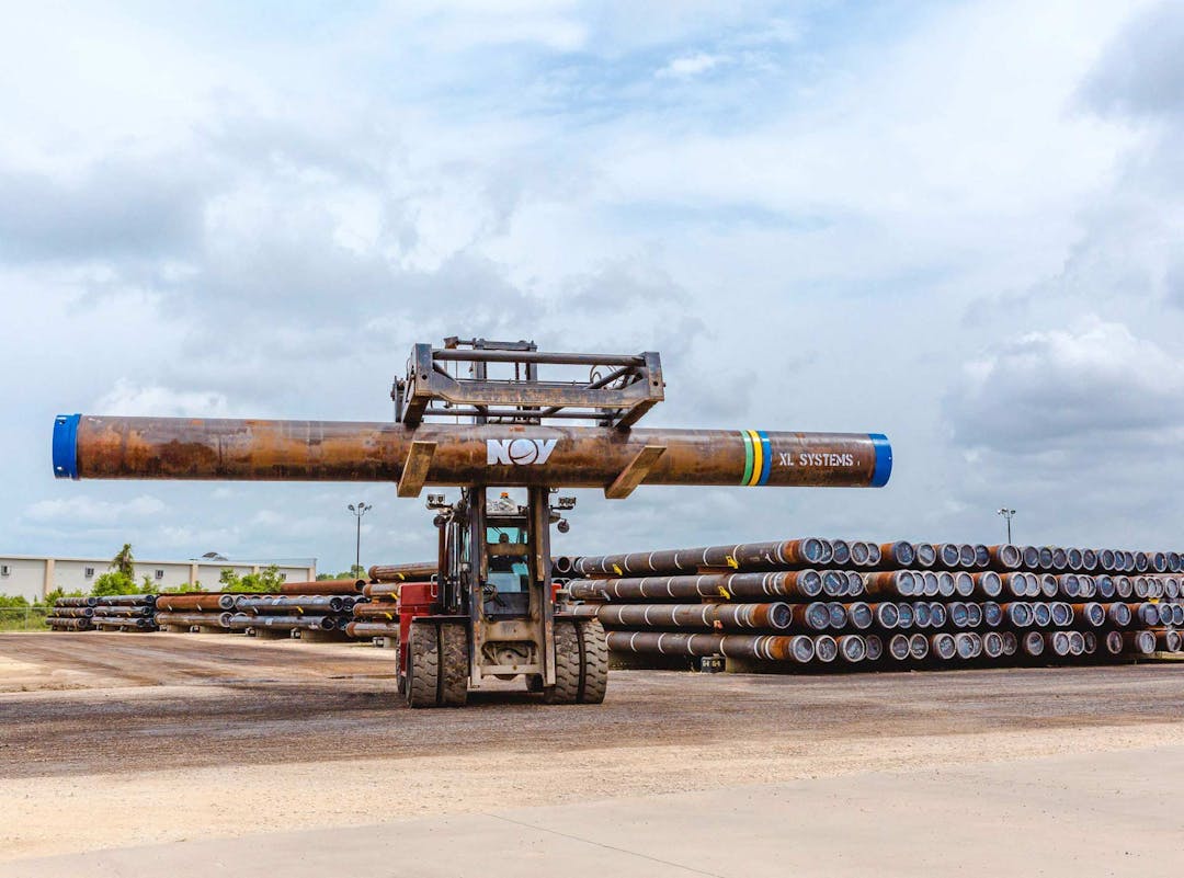 A forklift carries an XL Systems large diameter pipe through a storage yard