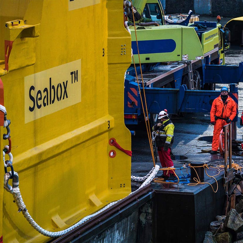 Workers look at a seabox subsea water treatment unit 