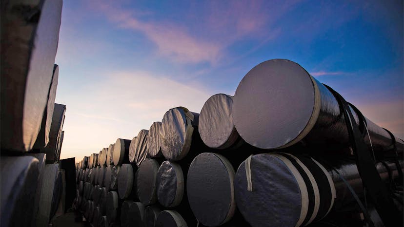 A series of sealed, stacked fiberglass pipe silhouetted against the sky