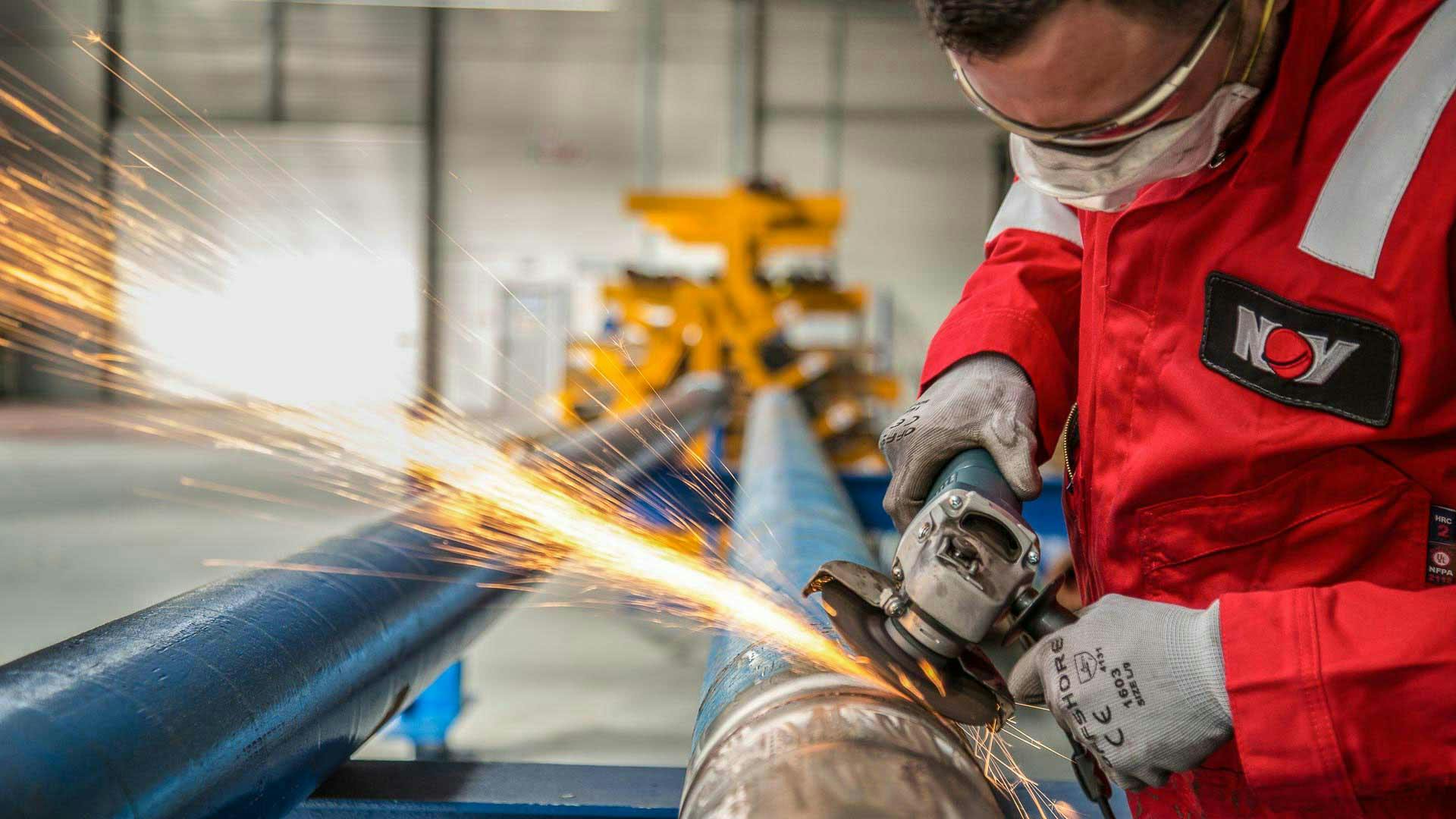 A technician cuts into a drill pipe in a manufacturing facility