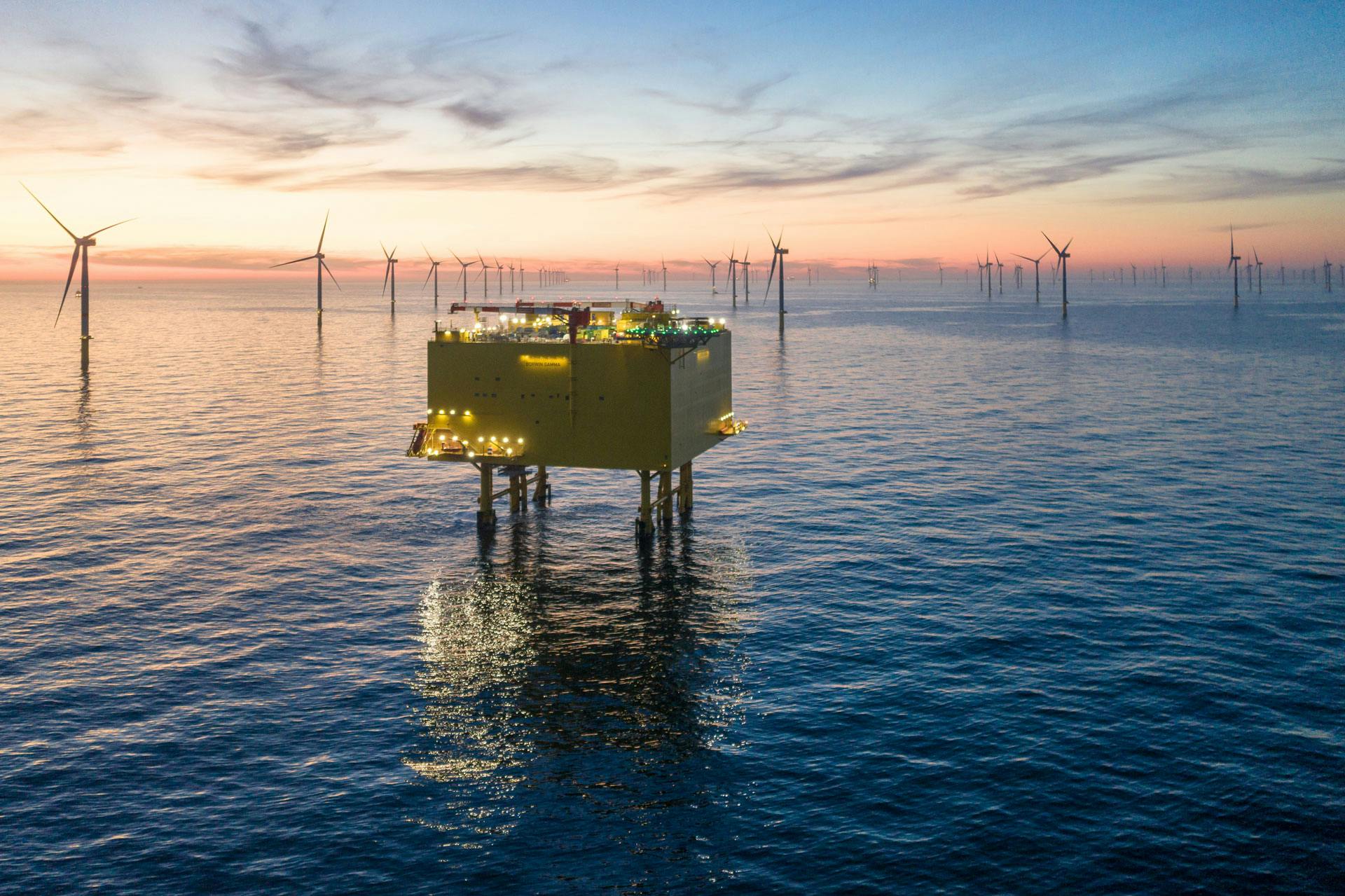 Offshore facility with turbines and horizon in the background, at dusk
