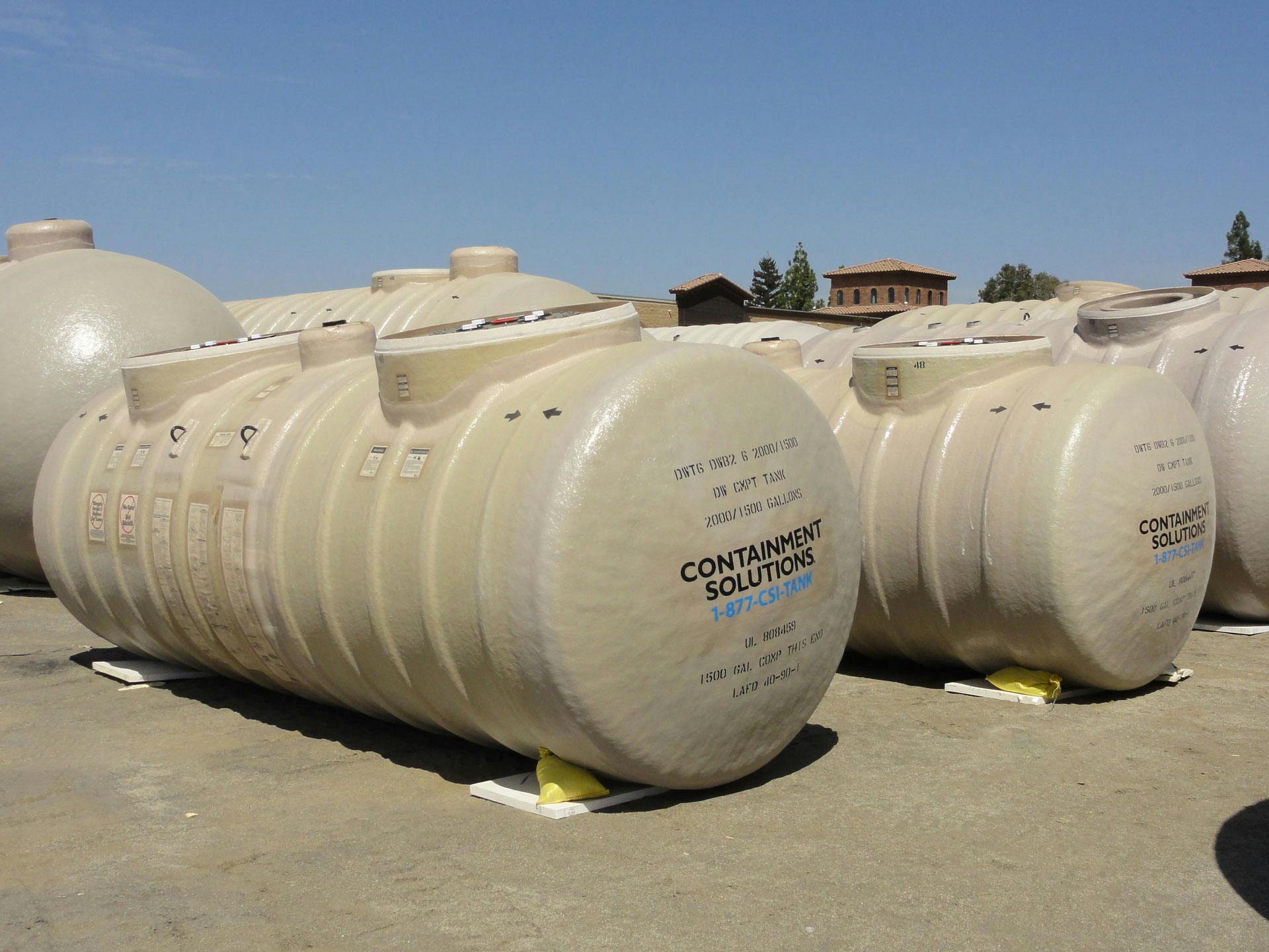 Fiberglass compartment storage tanks on the ground at the factory.