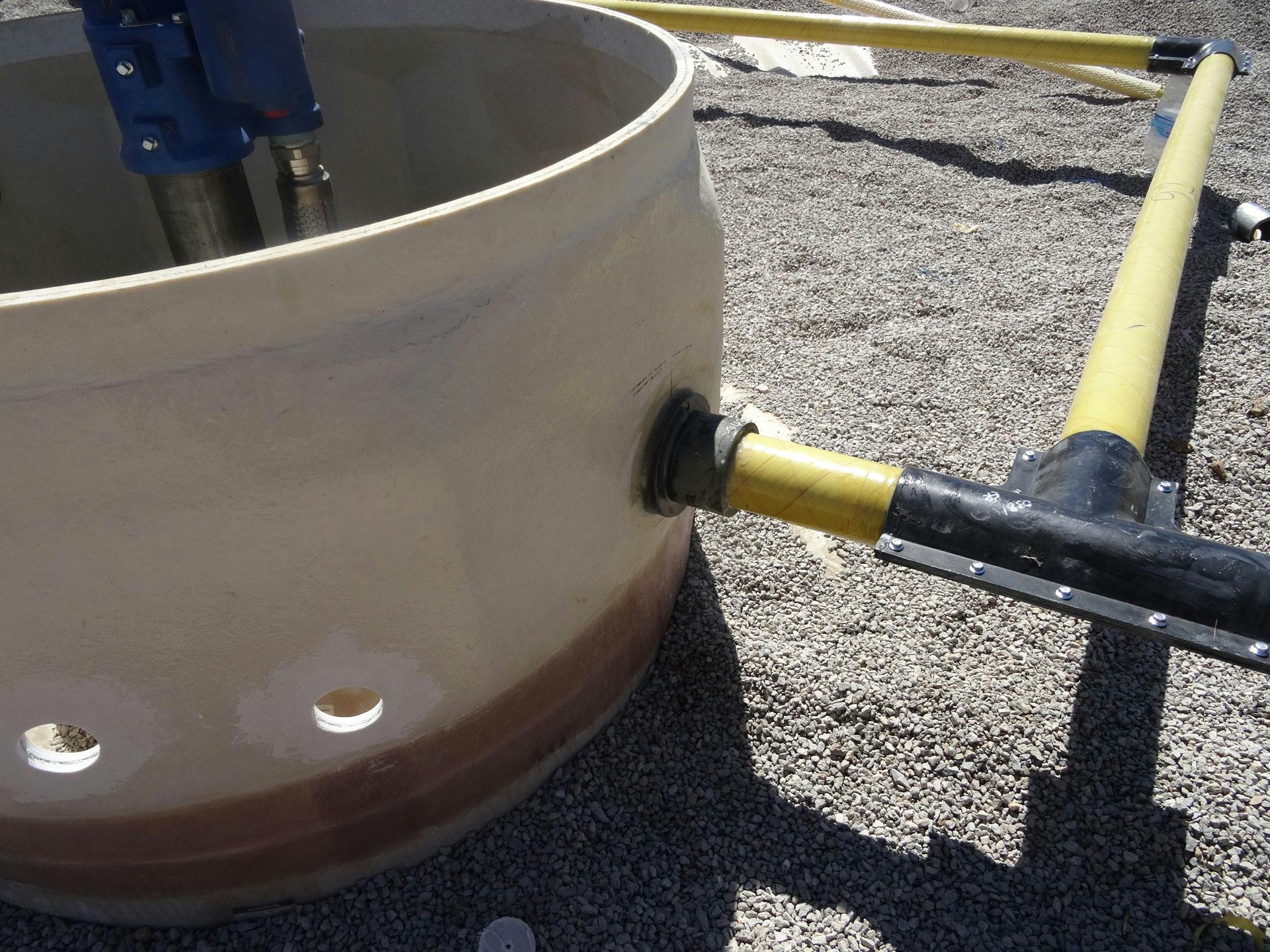 Fiberglass underground storage tank with a sump that has entry fittings for pipe. 