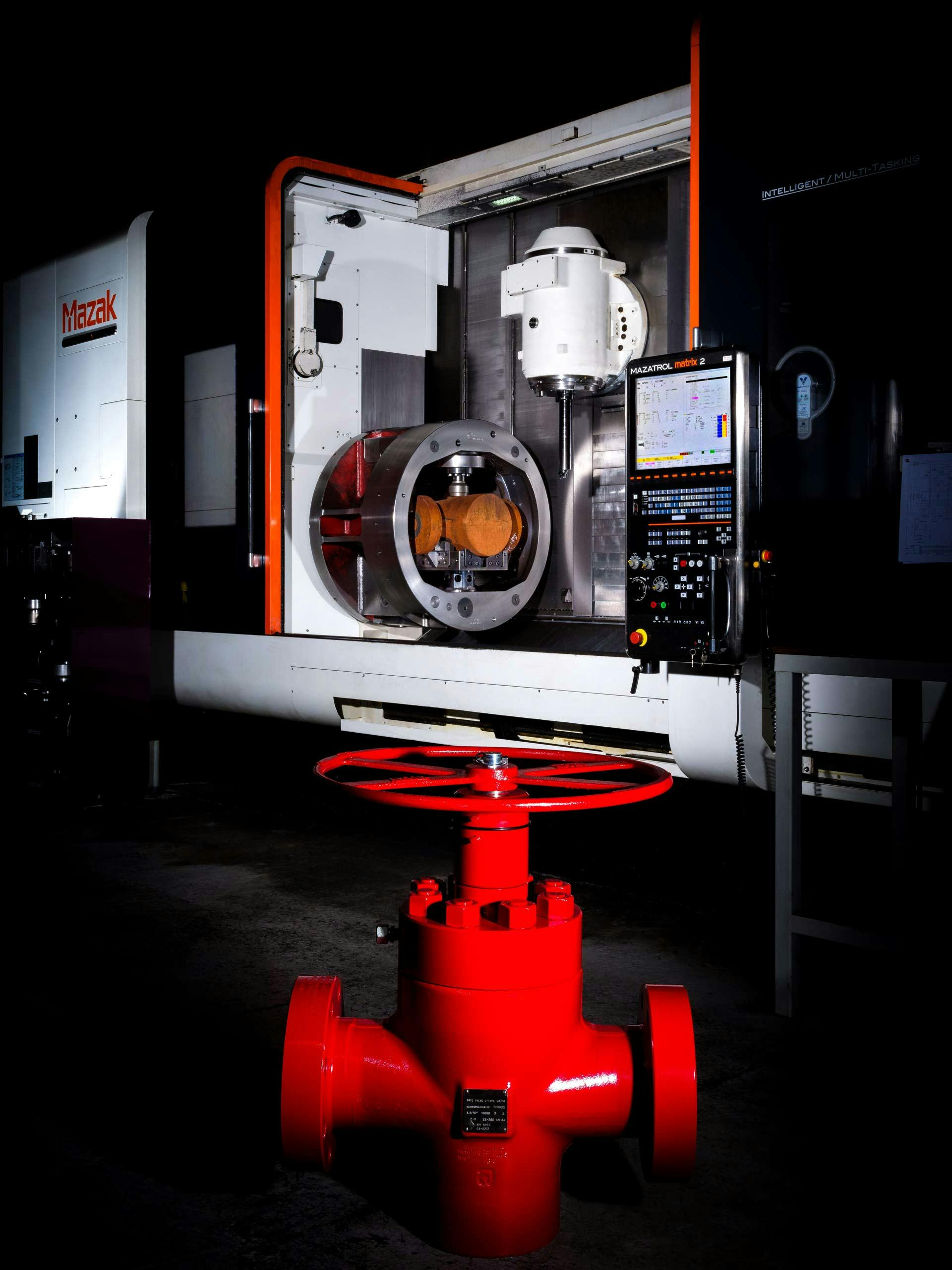 Photo of a gate valve and a gate valve machine in the background