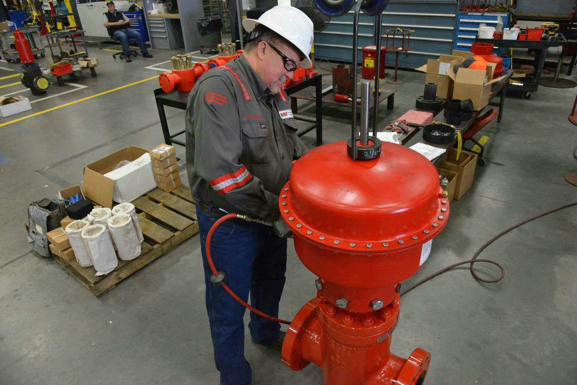 A technician works on a Pneumatic Shutdown Valve in a manufacturing facility