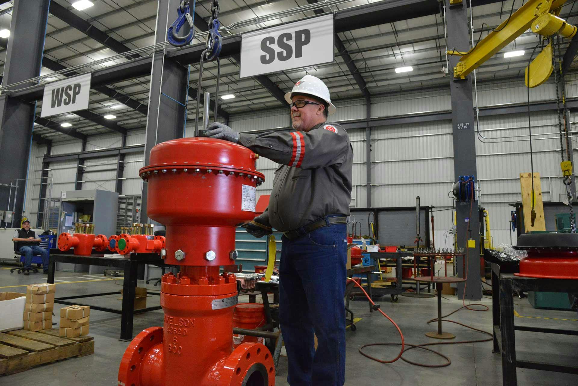 A technician works on a Pneumatic Shutdown Valve in a manufacturing facility