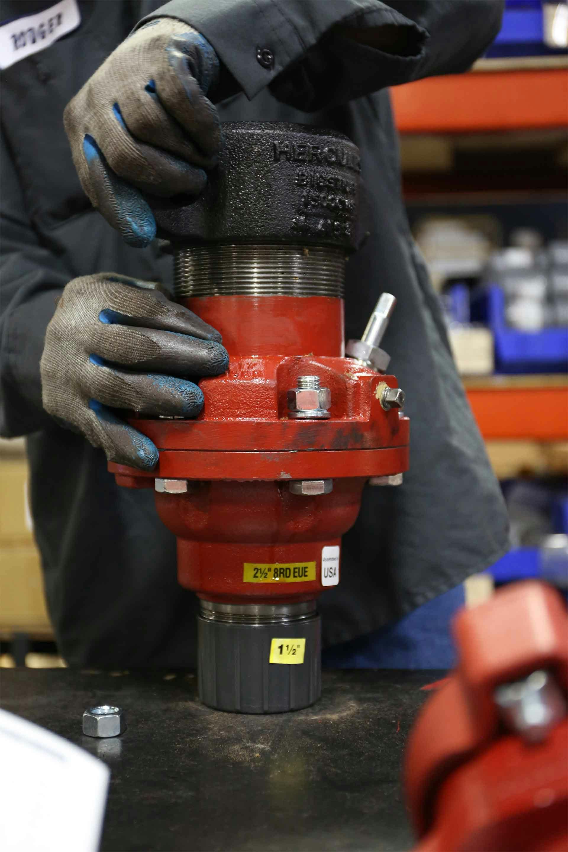 A technician works on a high-temperature stuffing box during manufacturing