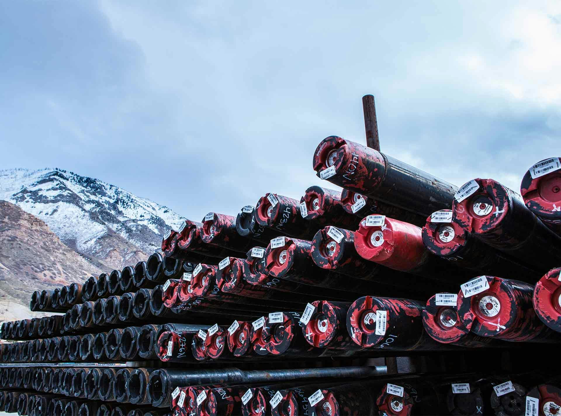 Close up of stacks of wired drill pipe with mountains in the background.