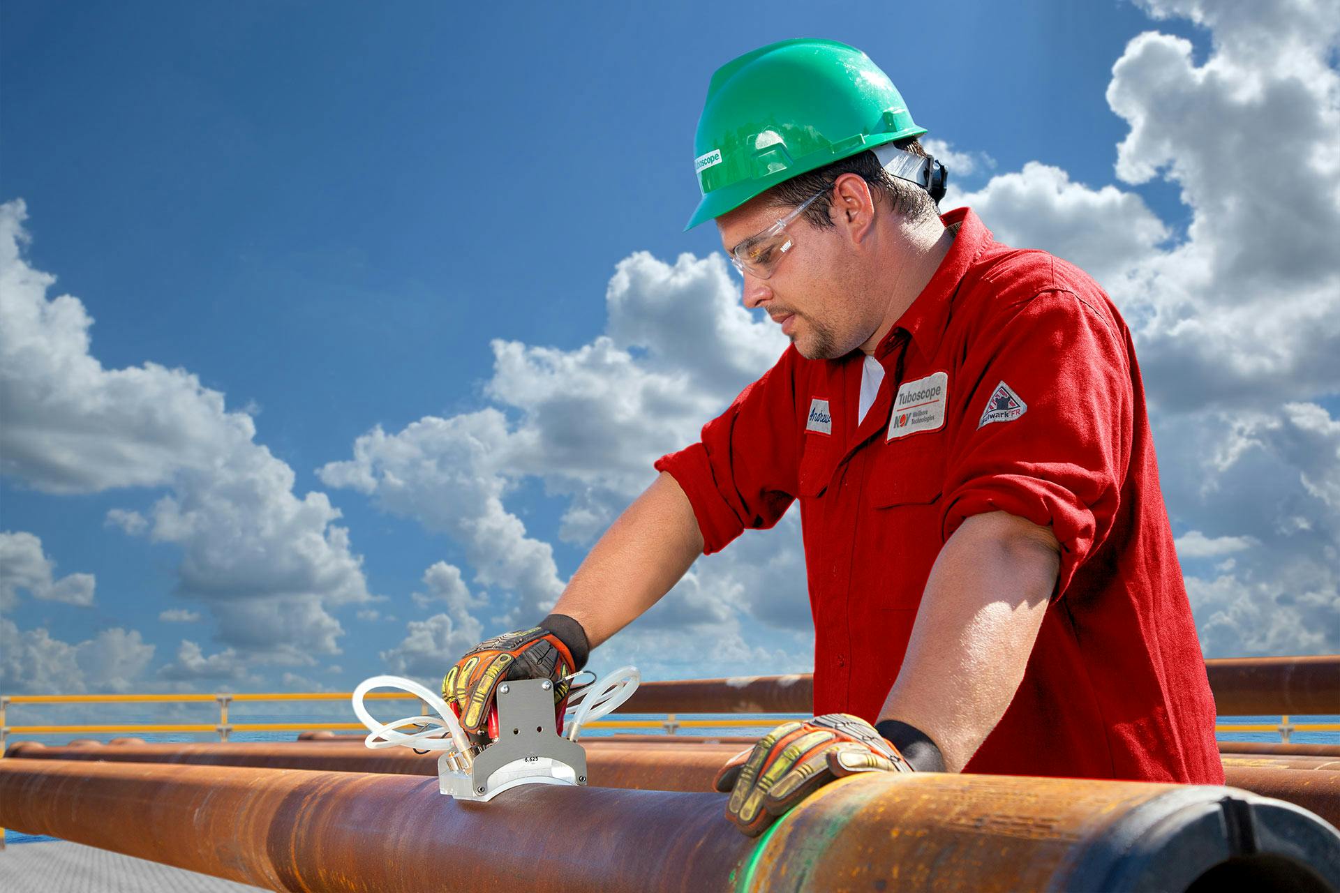 Worker inspecting drill pipe on offshore platform