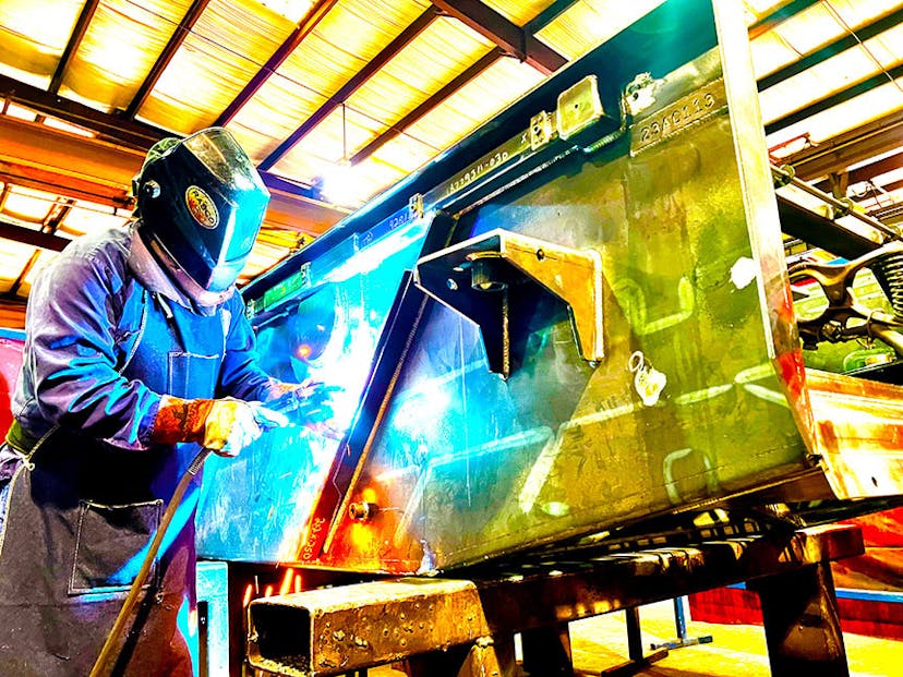 NOV employee welding an Alpha Shaker in a facility while wearing PPE