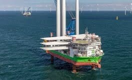Vessel installing wind turbine offshore.