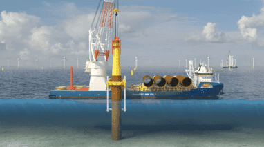 Offshore crane installing wind turbine foundation pile.
