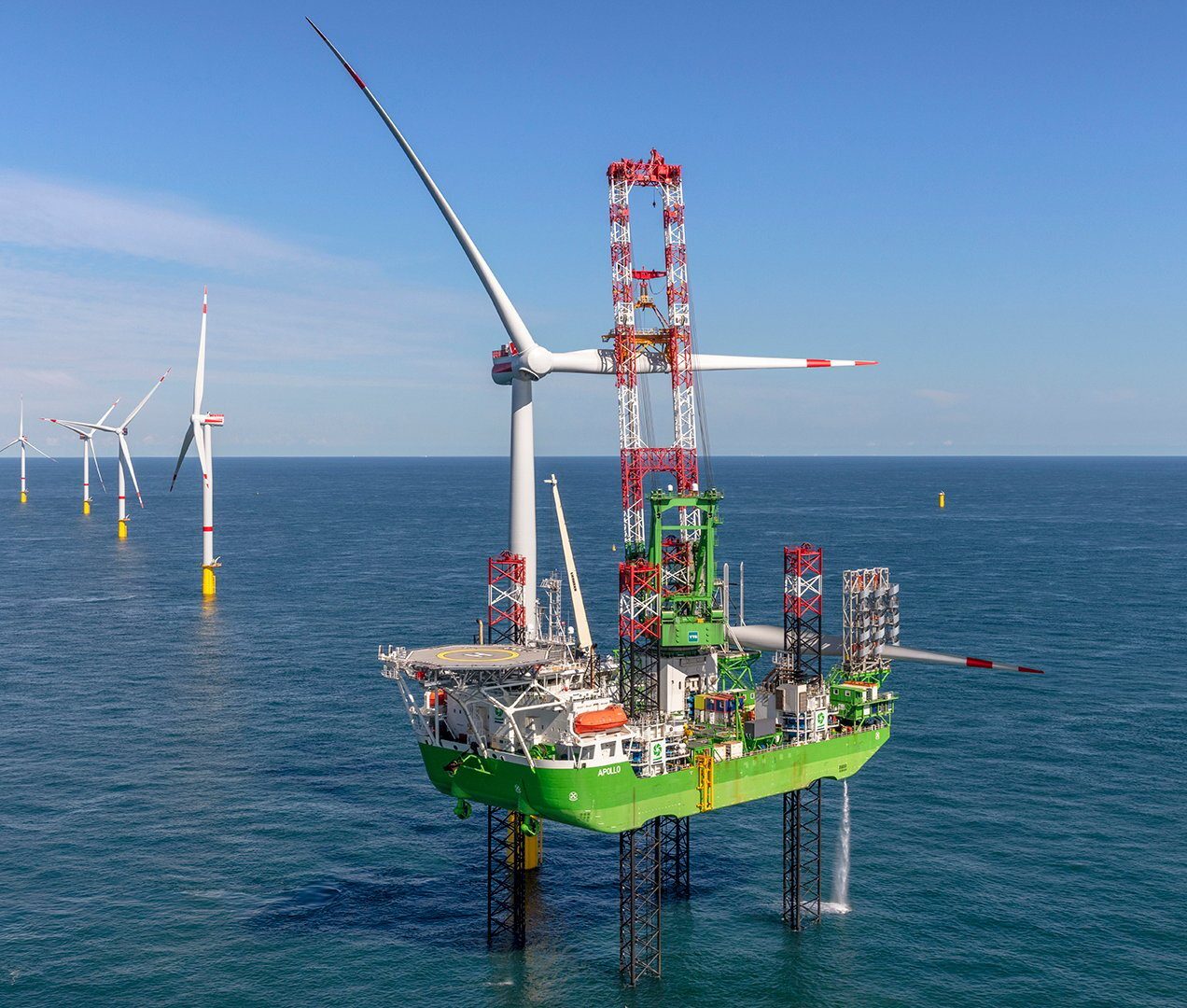 Green jack-up vessel 'Apollo' installs a wind turbine in an offshore wind farm.